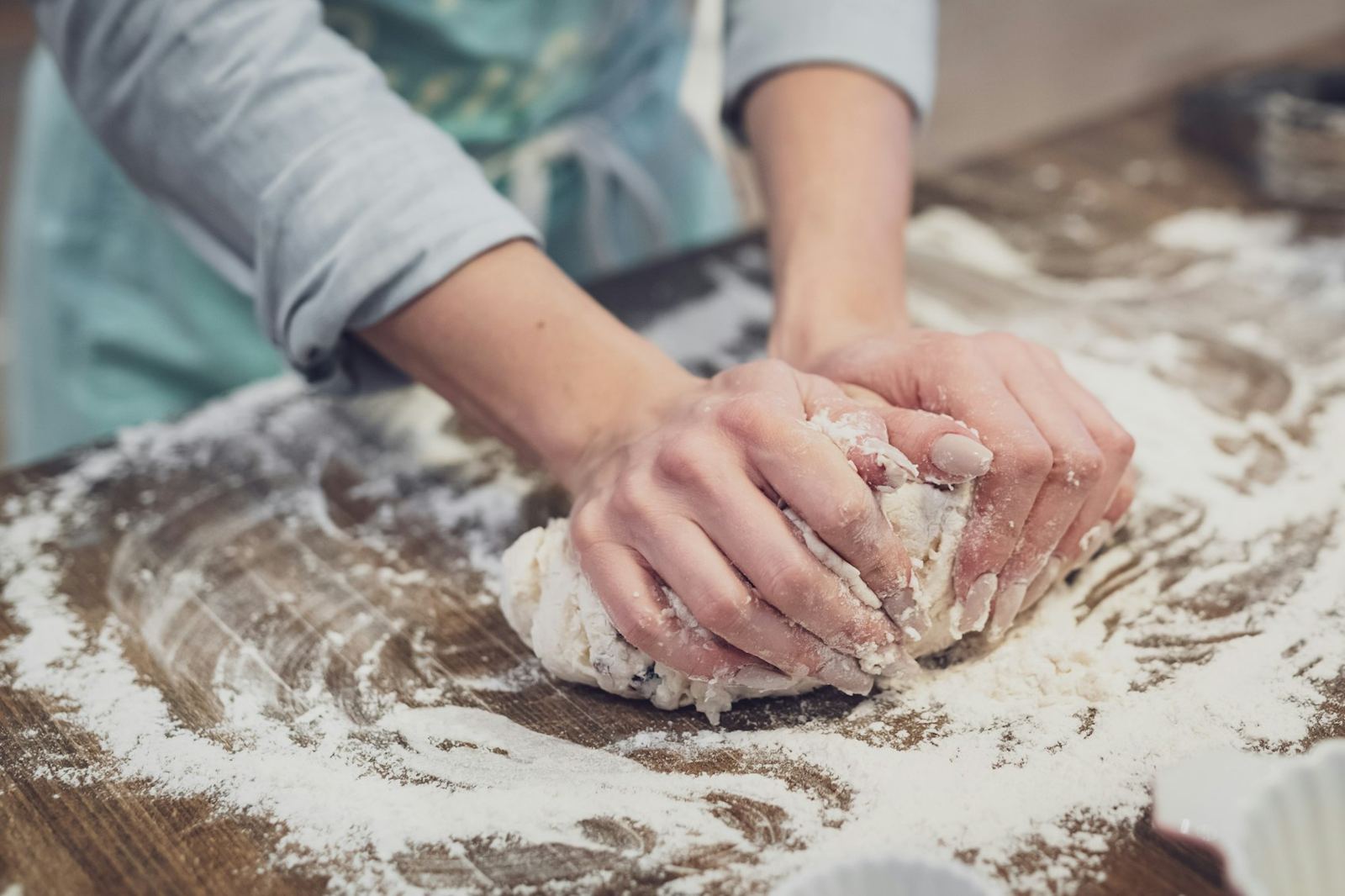 Baker shaping dough on a floured bench