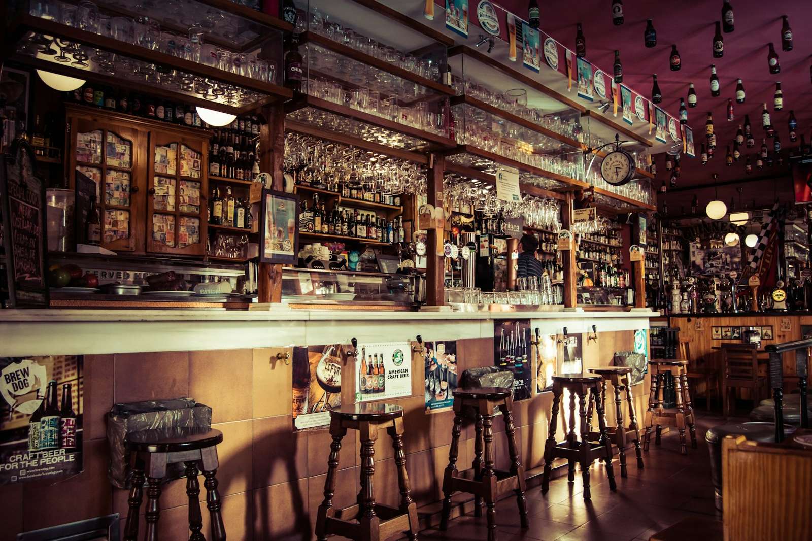 The long bar lined with stools and bottles