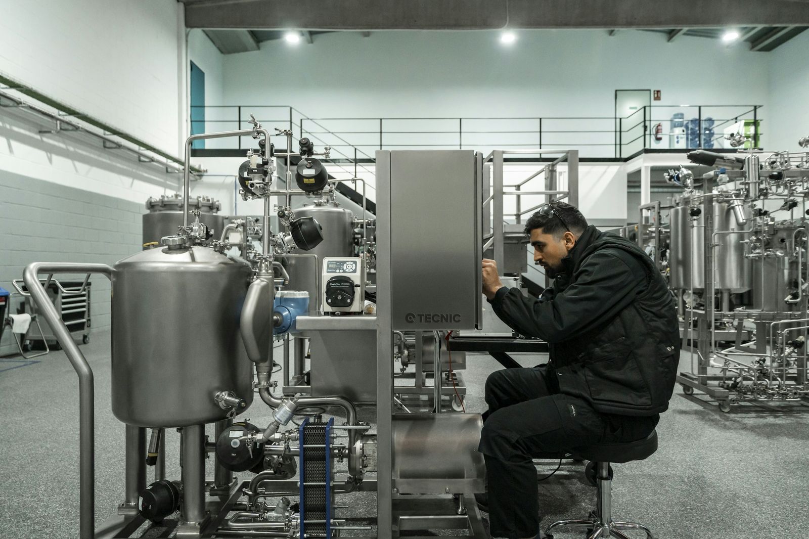 Technician inspecting stainless process equipment in a plant