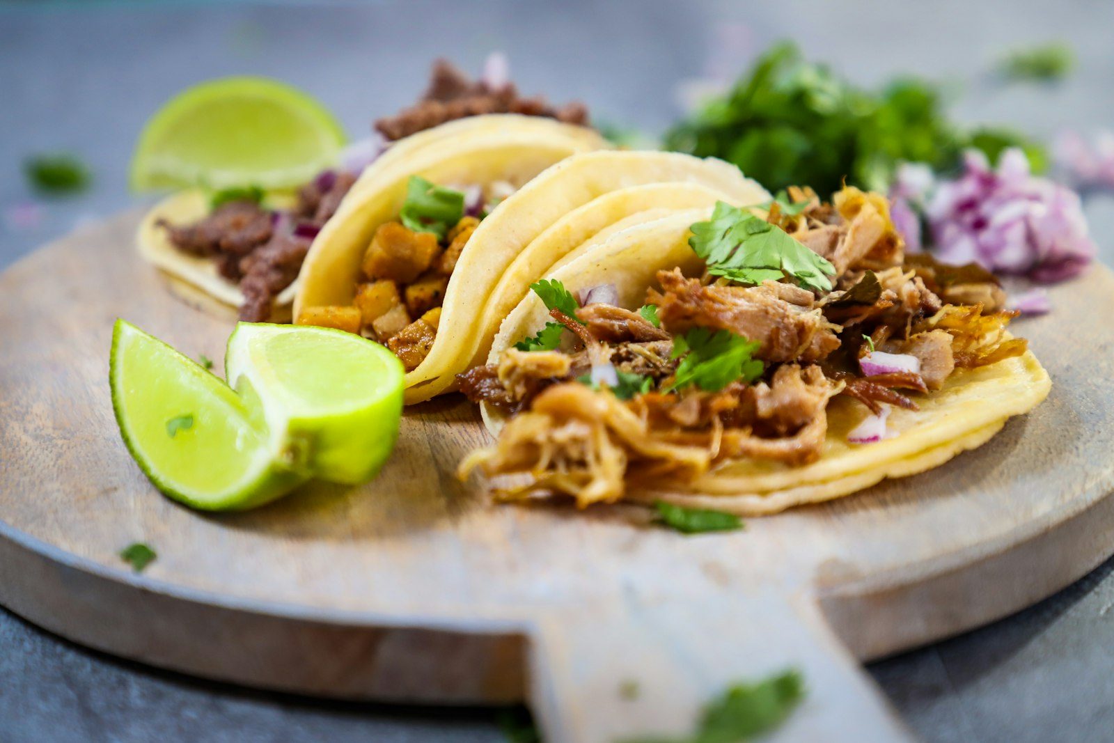 A platter of birria tacos with salsas and lime