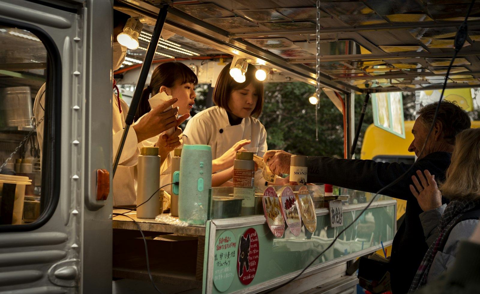 Cooks serving guests from a food truck window
