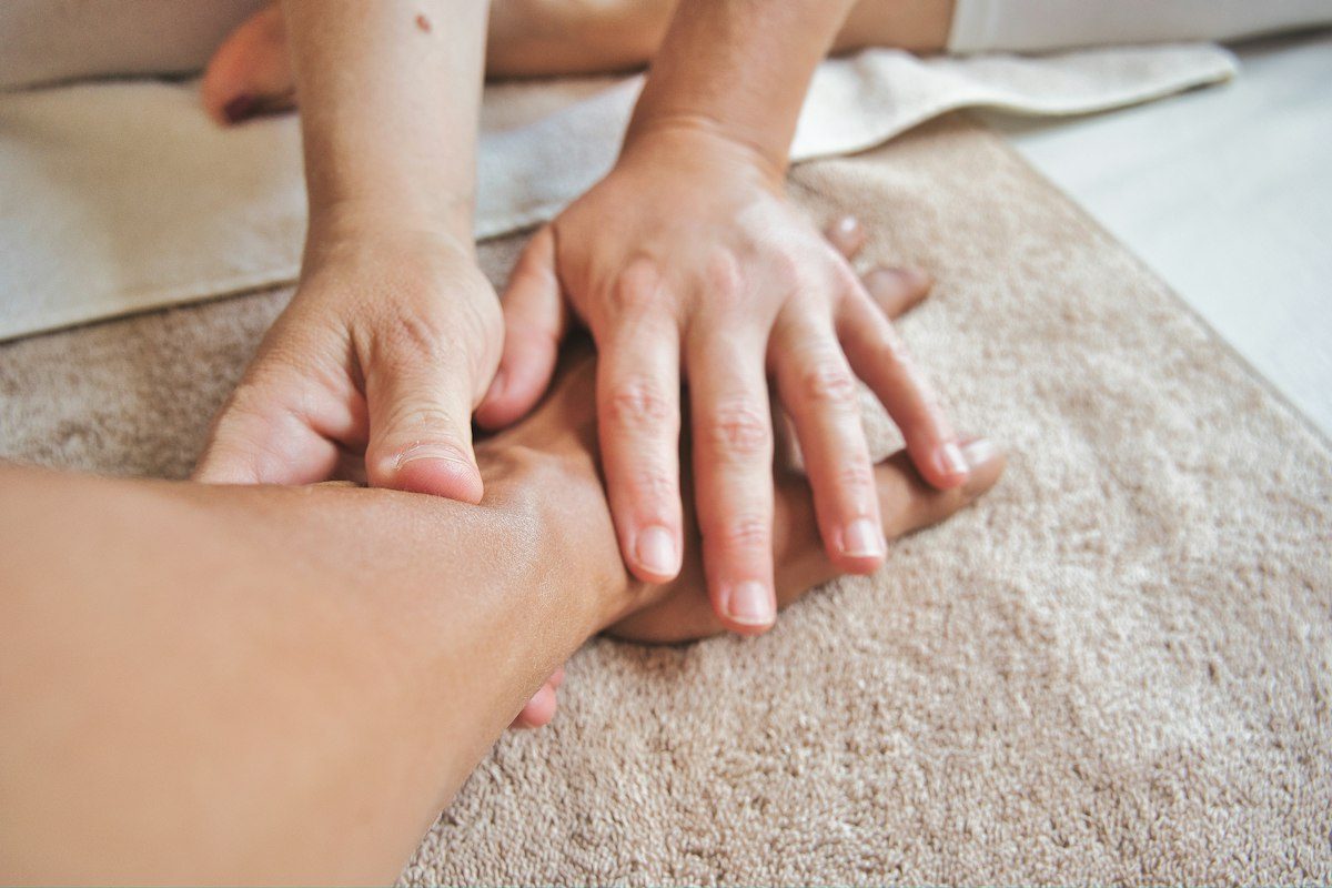 A person receiving a hand massage on a soft brown towel