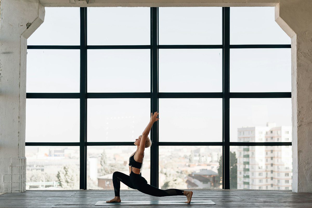 Woman in black tank top and black leggings doing yoga
