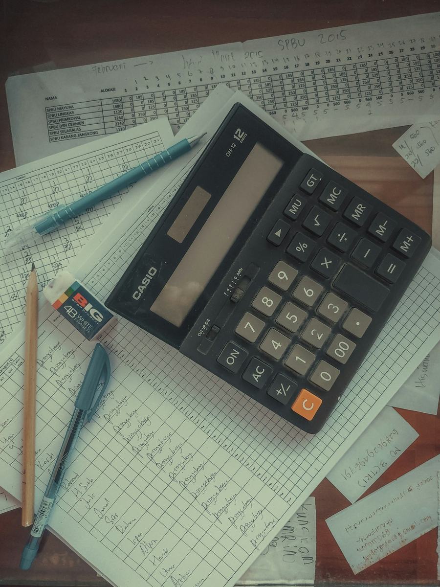 A calculator sitting on top of a pile of papers