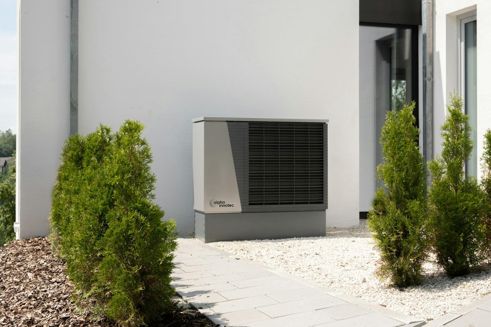 Outdoor heat pump unit beside a white house