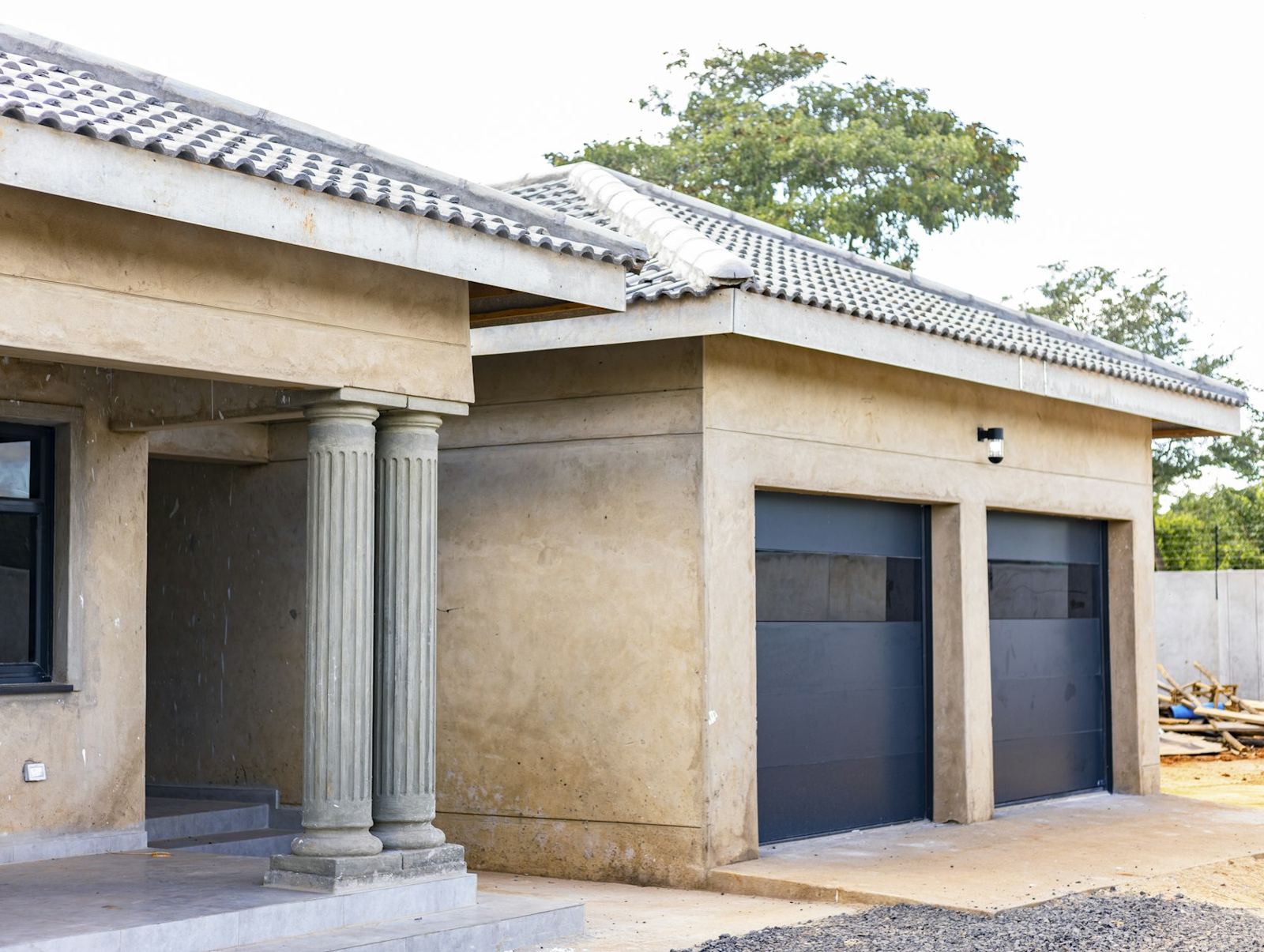 Two dark garage doors on a stucco home