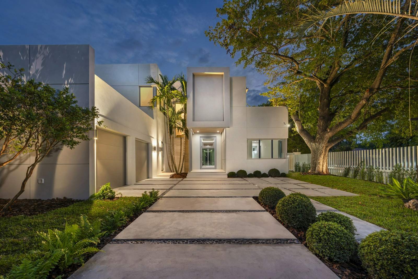 Modern home at dusk with lit walkway