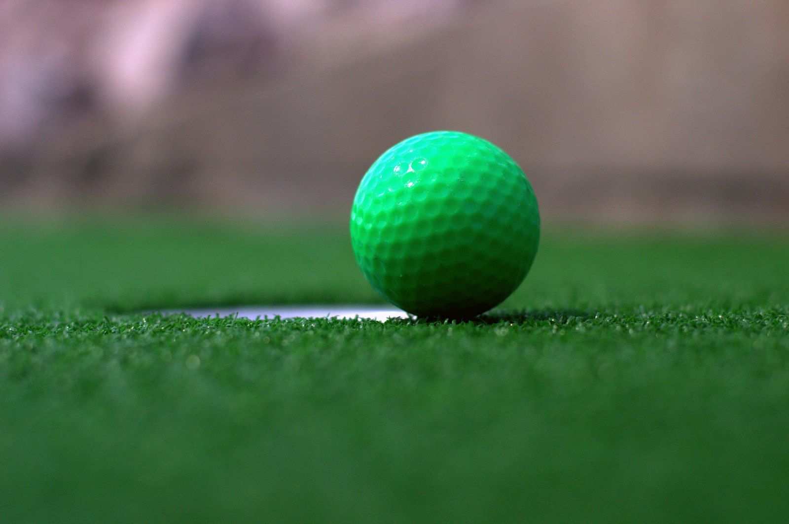 Green ball at the edge of the cup