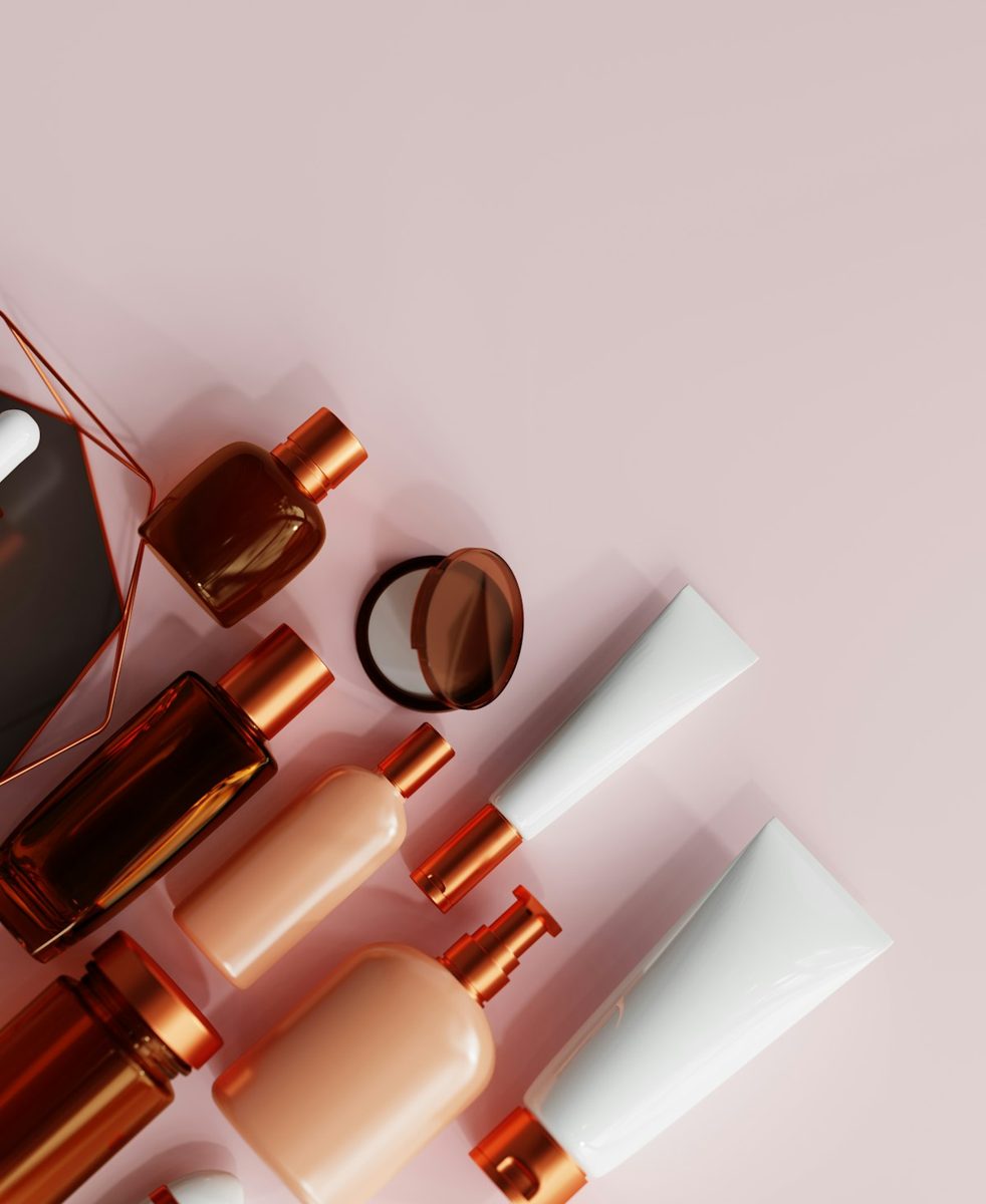 An assortment of makeup products on a pink background