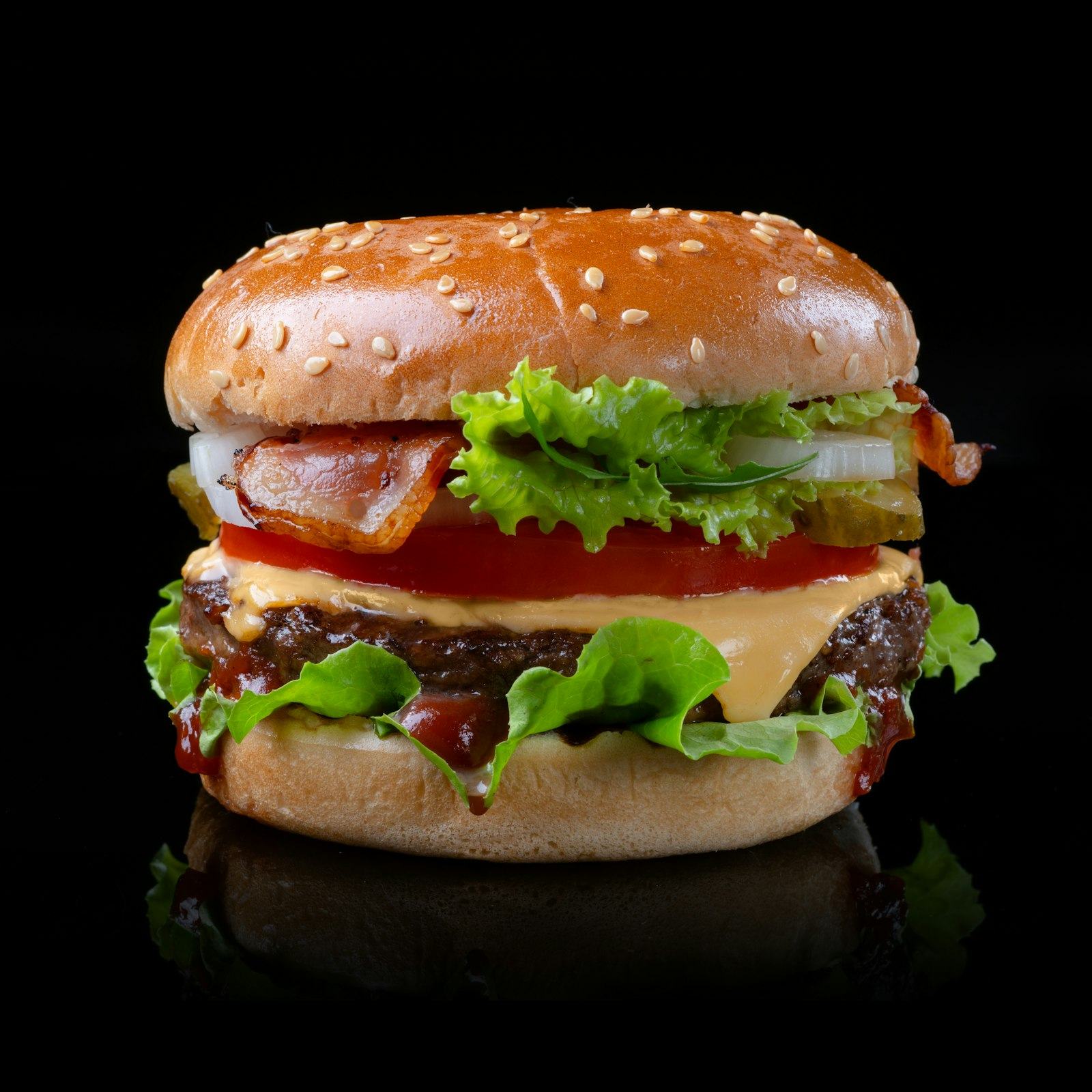 A tall smashed cheeseburger with lettuce and tomato