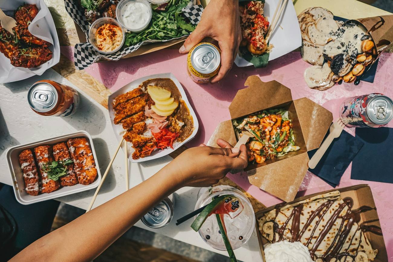 Shared table covered with food from different stalls