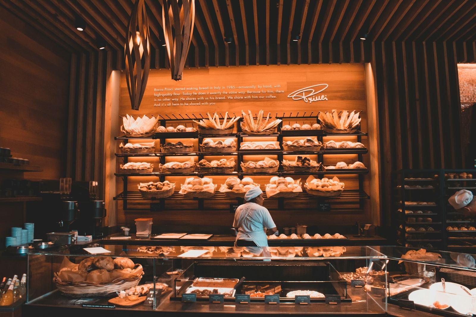 A warm bakery counter with shelves of pastries