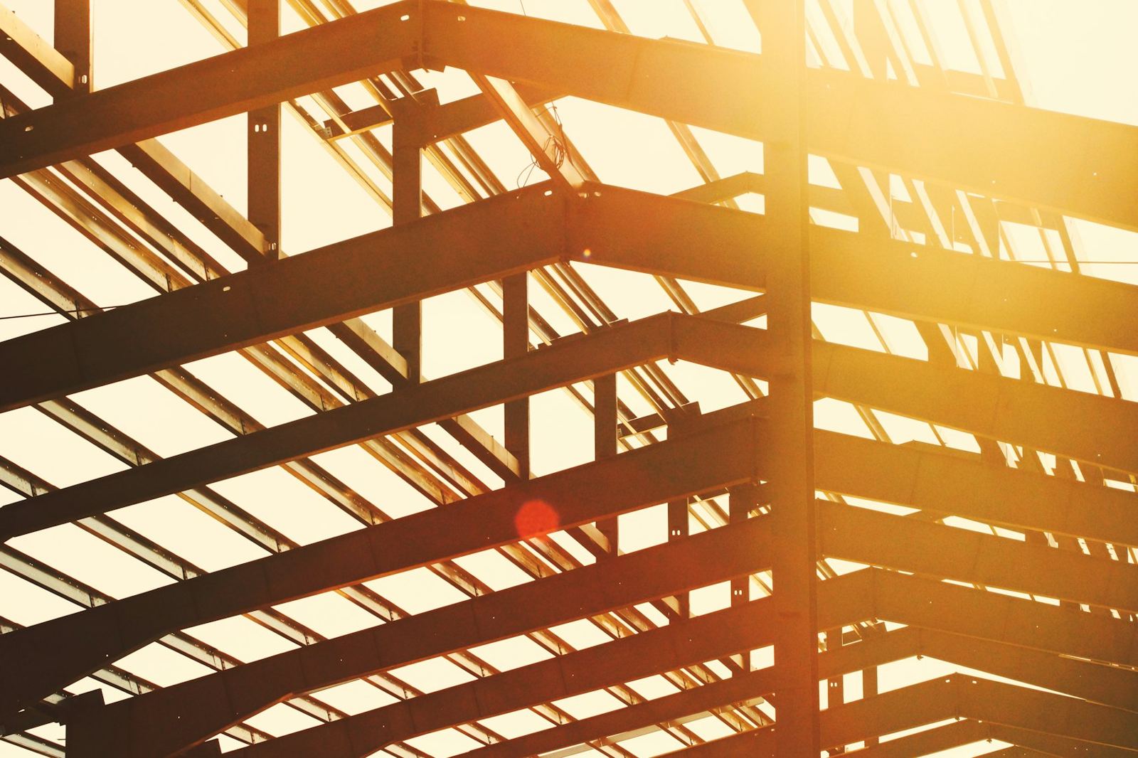 Steel roof framing lit by sunlight