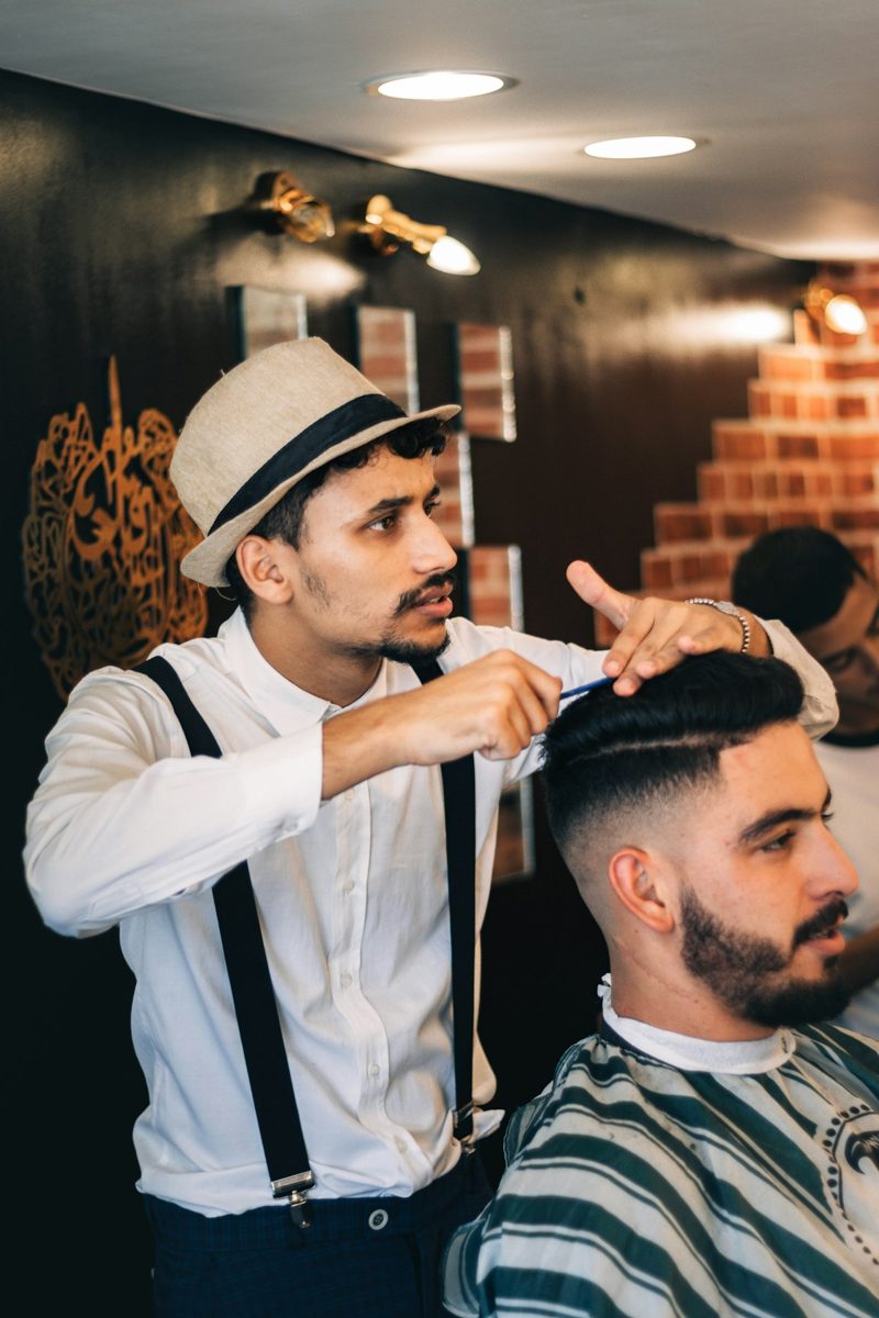 A man getting his hair cut by a barber