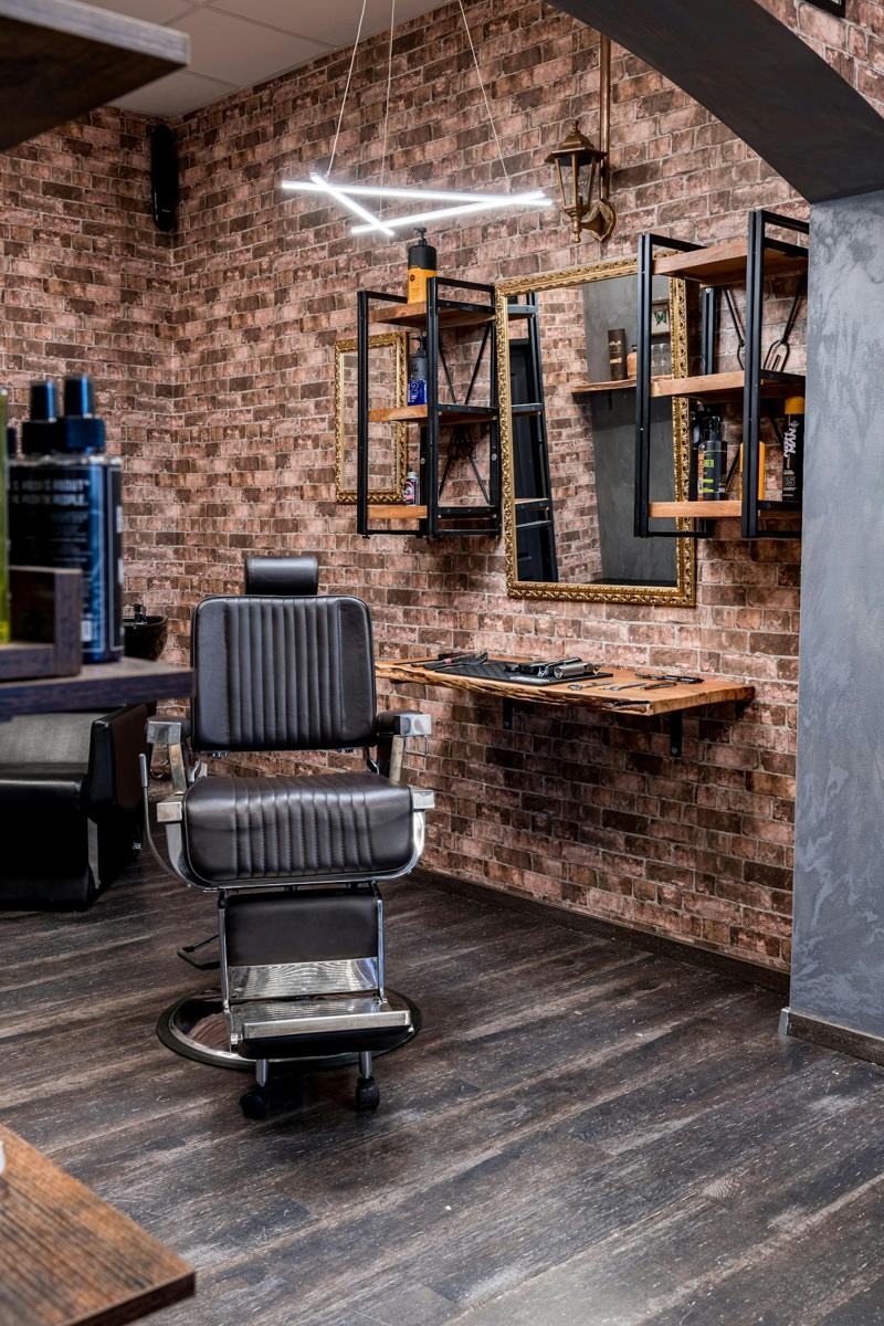 A barber shop with a brick wall and wooden floors