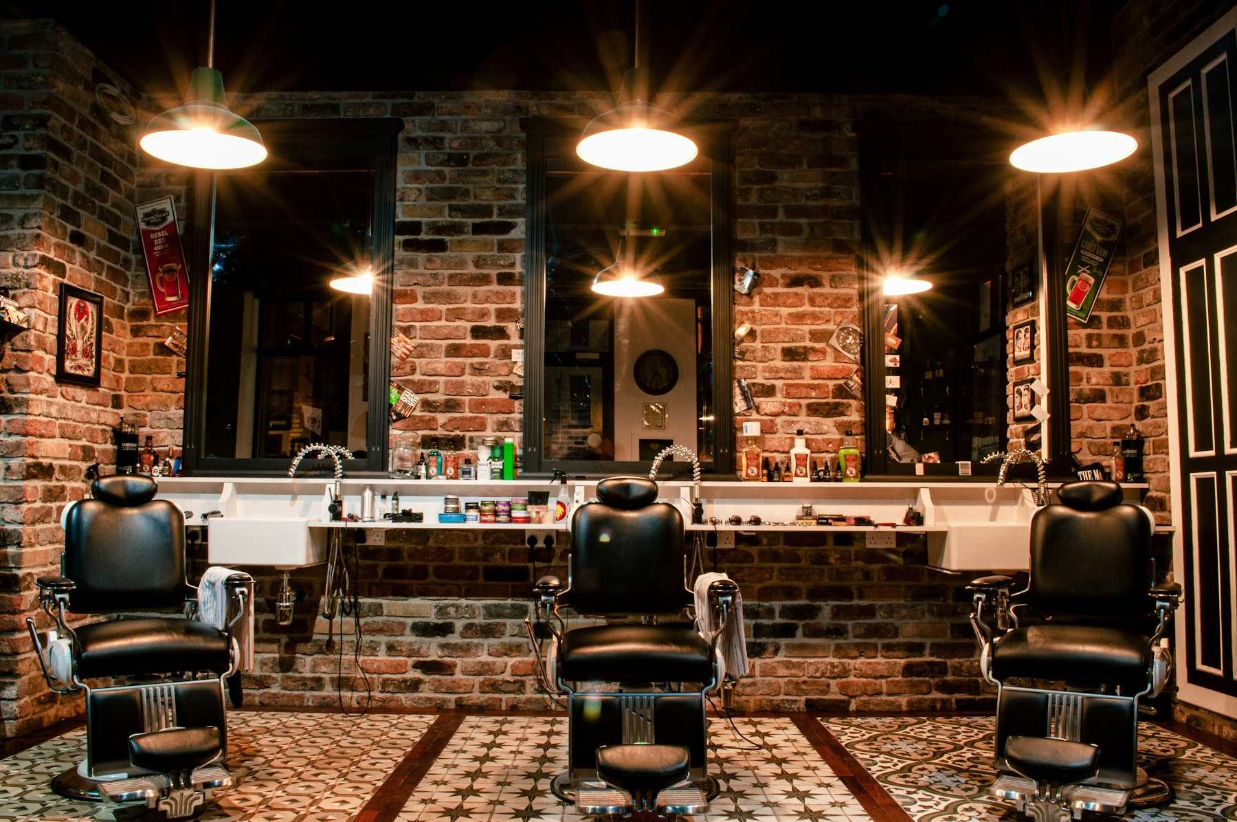 Black leather barber chair near brown brick wall