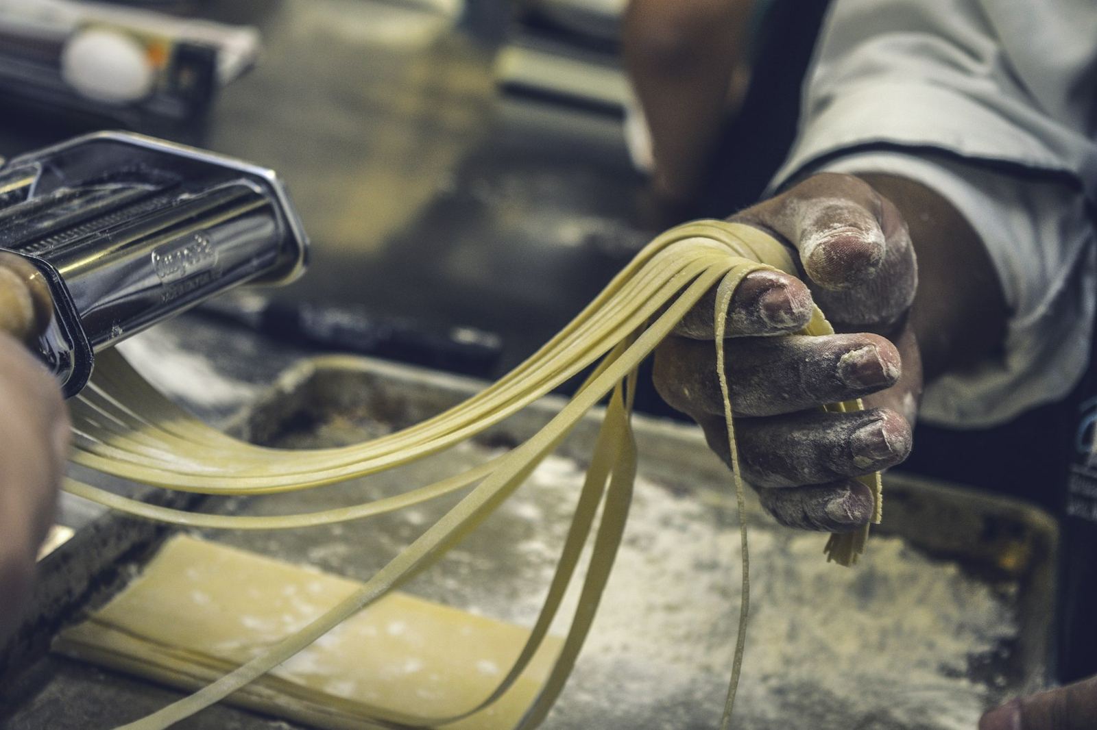 Fresh pasta being cut by hand