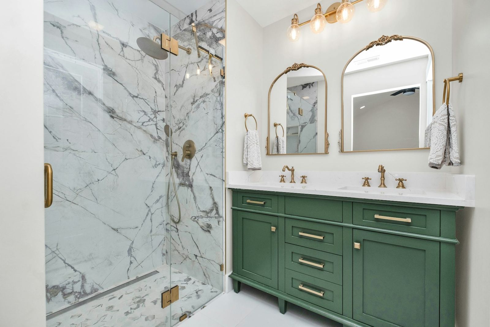 Green vanity with marble shower