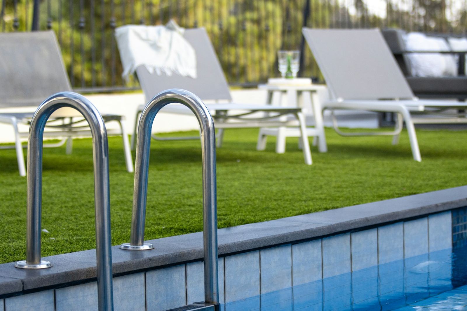 Pool edge with ladder and lounge chairs