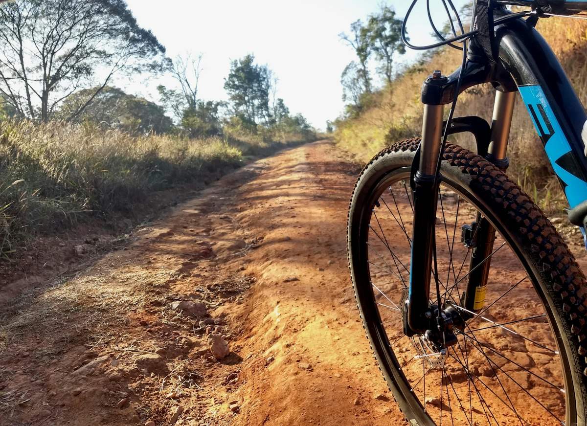 Black mountain bike on brown dirt road during daytime