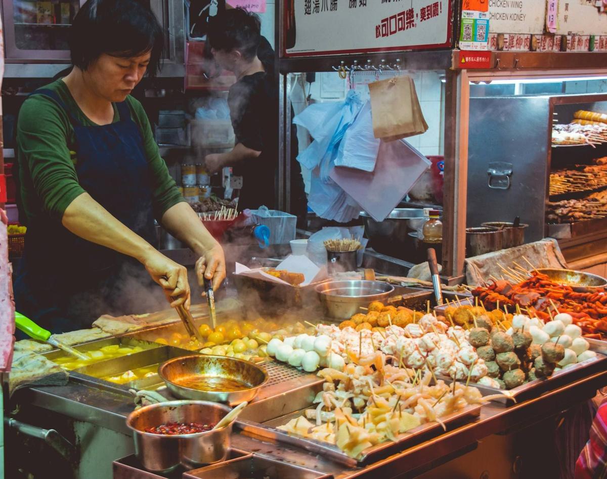 A cook at a busy street-food counter