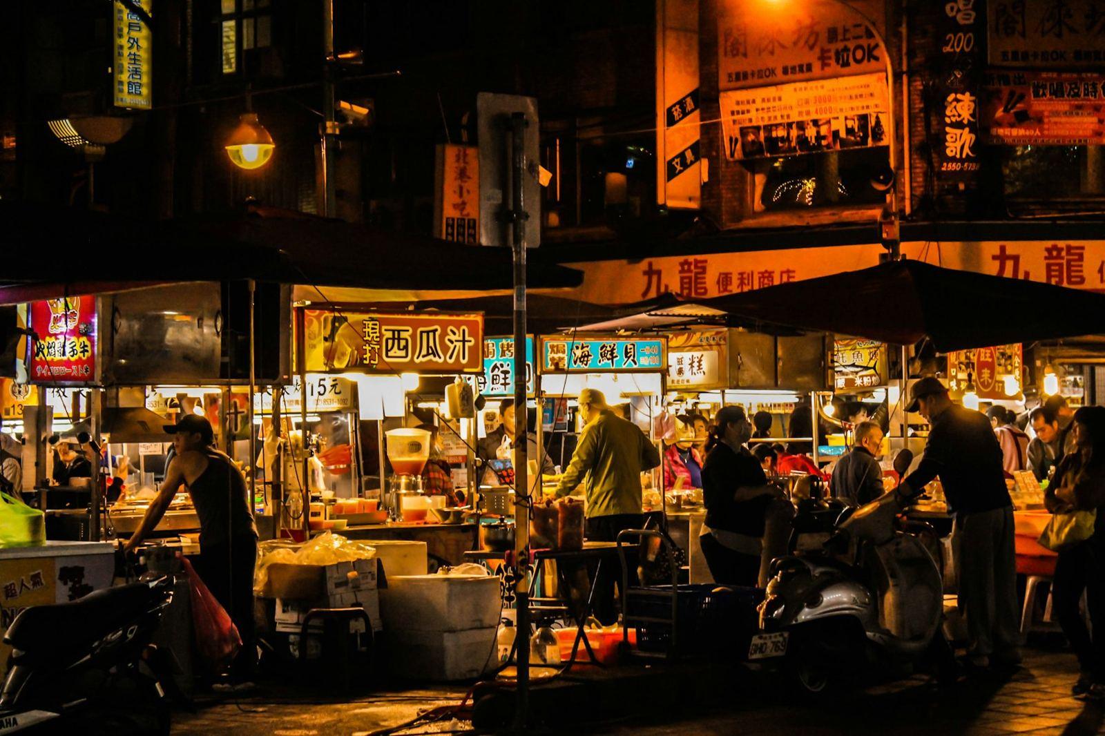 A busy night market with glowing stalls and hot food