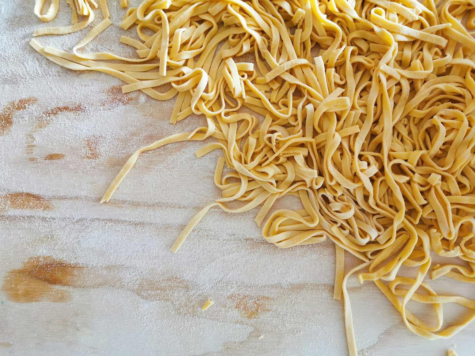 A pile of fresh egg tagliatelle on a floured table