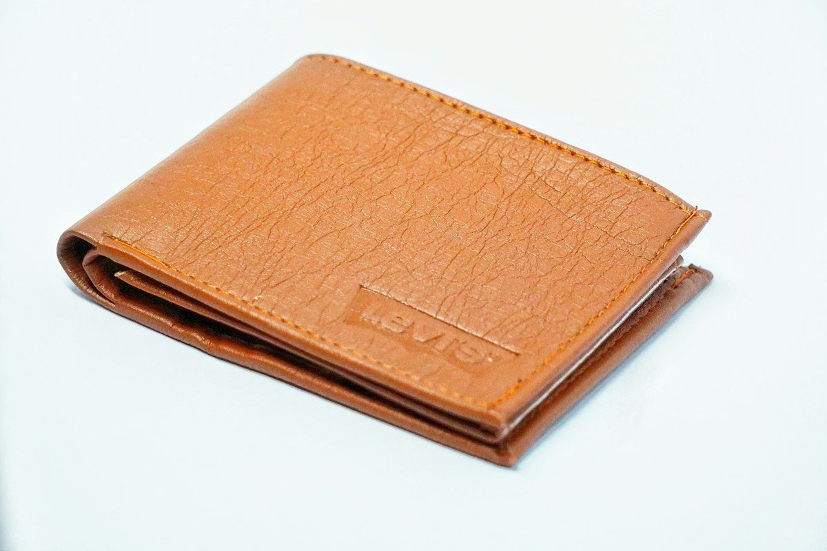Brown leather bifold wallet on white table