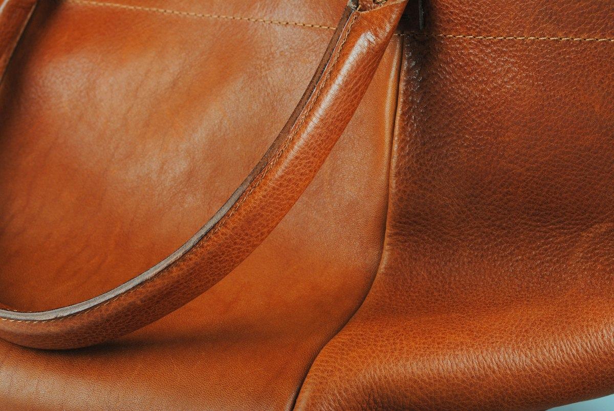 A brown leather handbag with a long strap