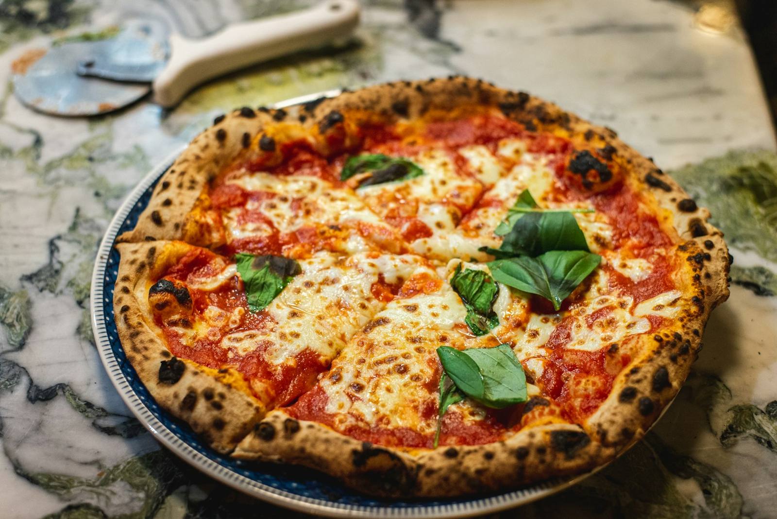 A margherita pizza with fresh basil on a plate