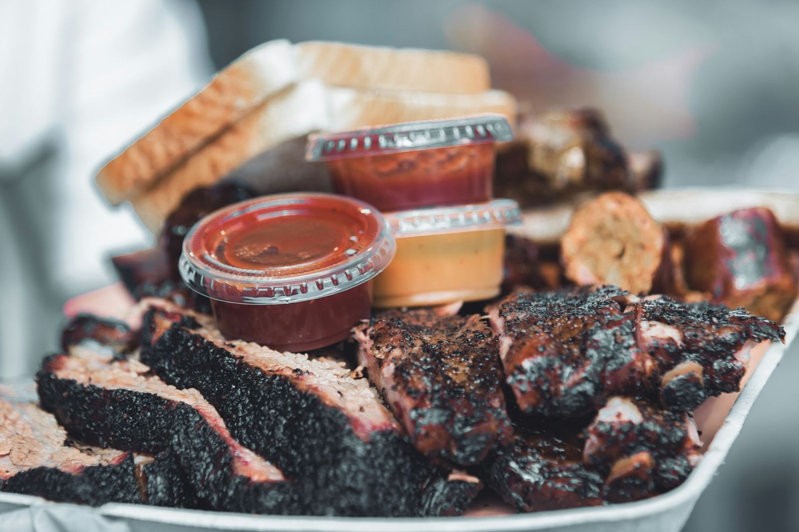 Trays of brisket and sauce cups ready to serve