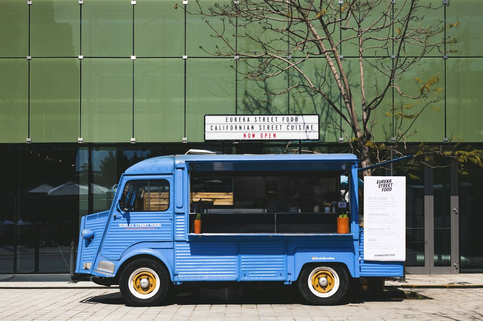A blue food truck parked outside a building