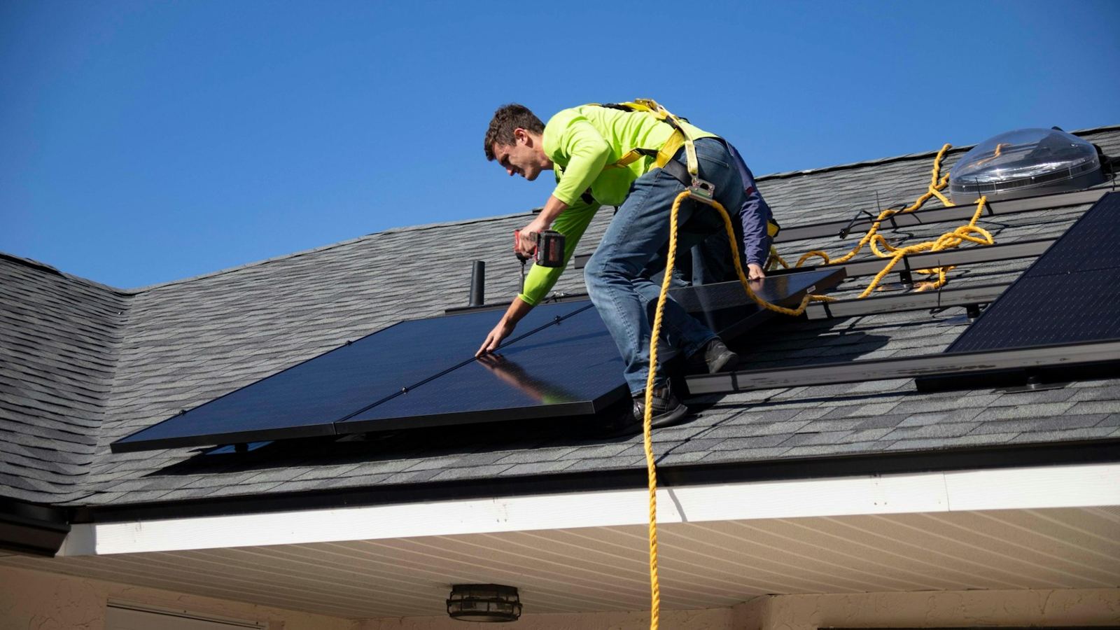 Installer placing a solar panel on a roof