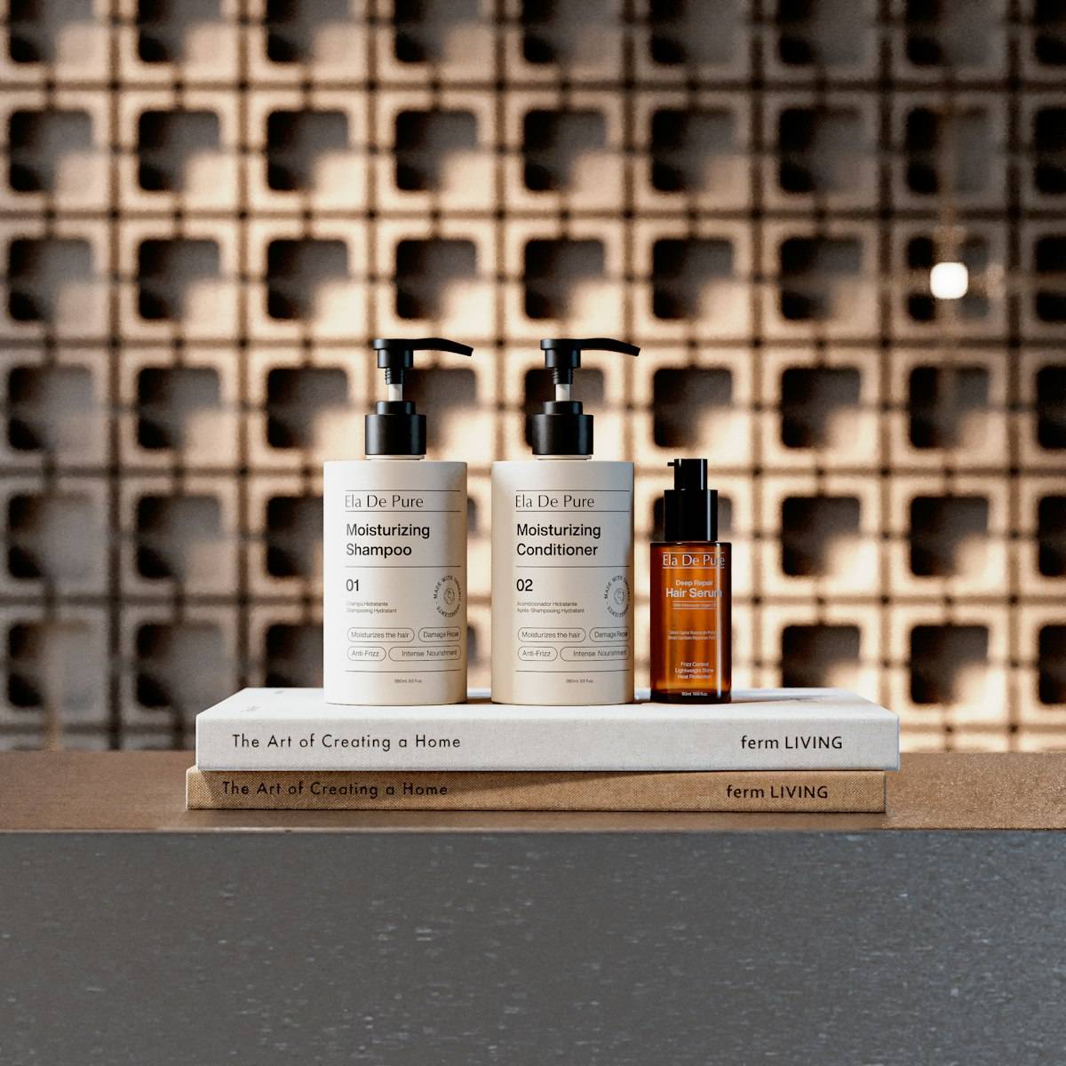 Three cosmetic bottles on books against a patterned wall