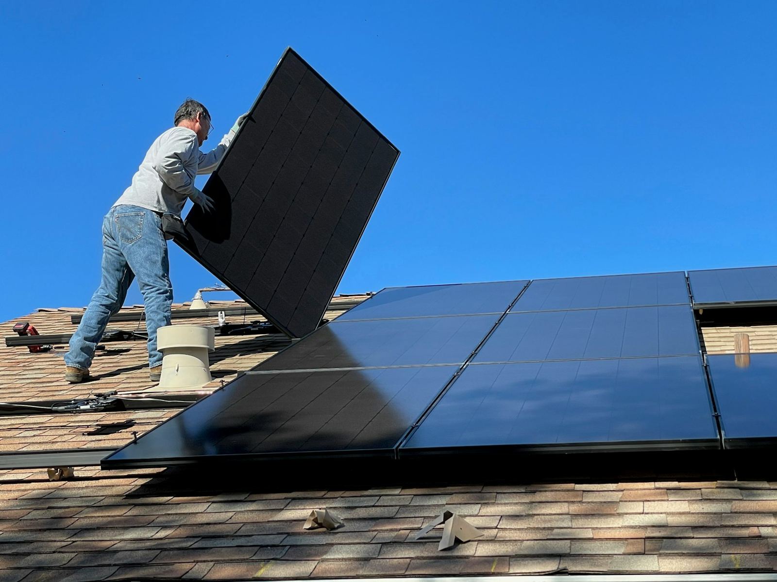 Installer lifting a panel onto a roof