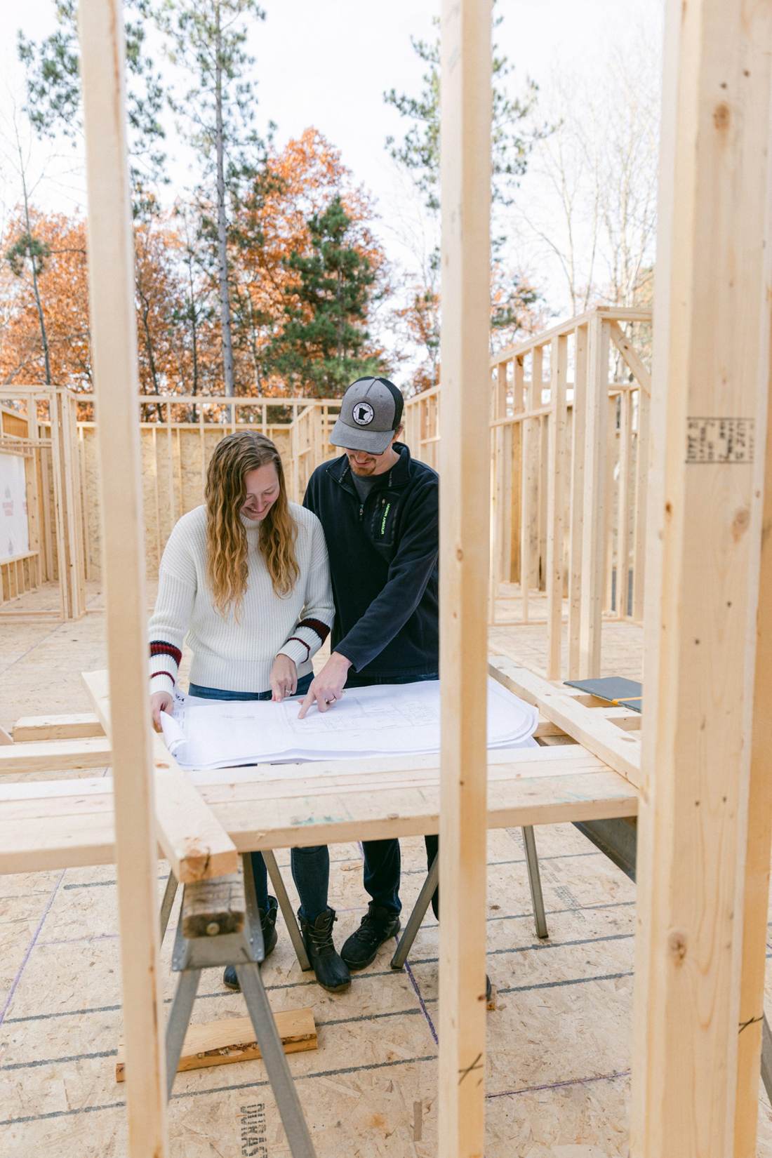 Two people reviewing plans inside a timber frame