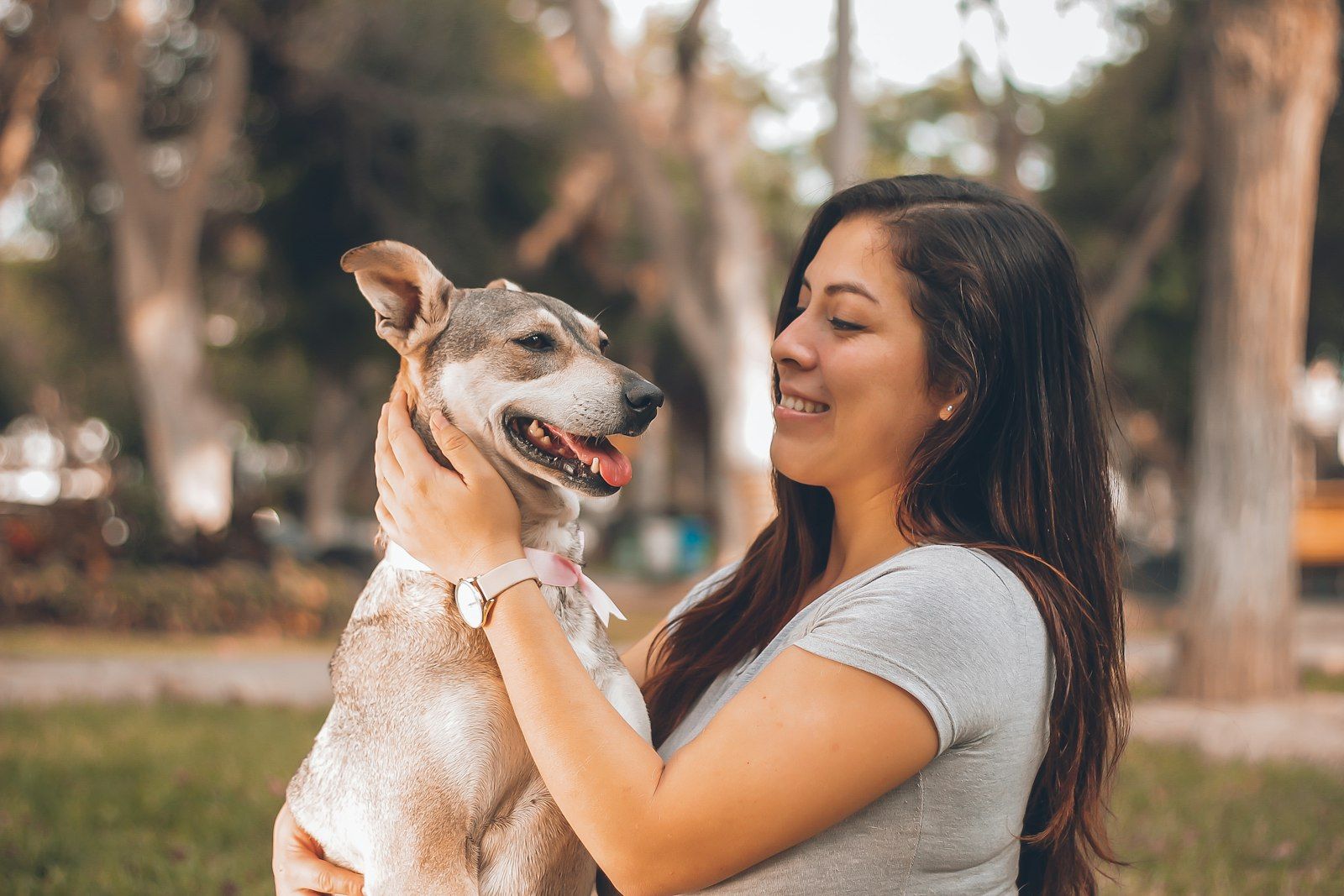 Woman holding her dog outdoors