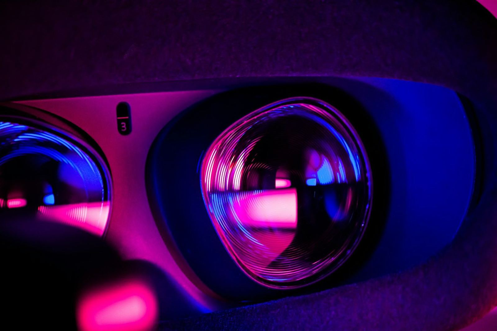 Close-up of a headset lens glowing pink